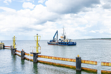 ship with excavator for dredging the entrance to the port