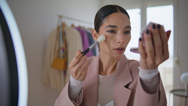 Visage influencer applying powder recording beauty blog. Makeup artist talking