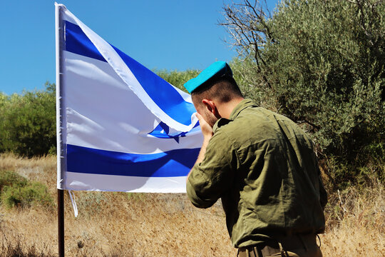 Israel Defense Forces soldier mourns in front of the Israeli national flag. Concept photo: IDF, Tzahal, Memorial Day for the Fallen Soldiers of the Wars of Israel and Victims of Actions of Terrorism