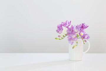 purple freesia in glass vase on white background