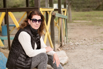 The woman at autumn enjoying the last warm days before lingering rains and cold, woman sitting on the farm and resting after a hard work stressful week