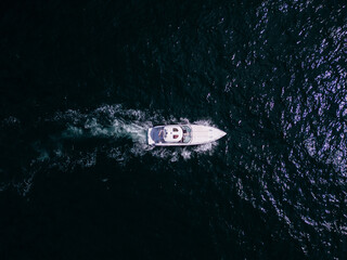 Aerial view of a pleasure boat racing through the sea waves, cre