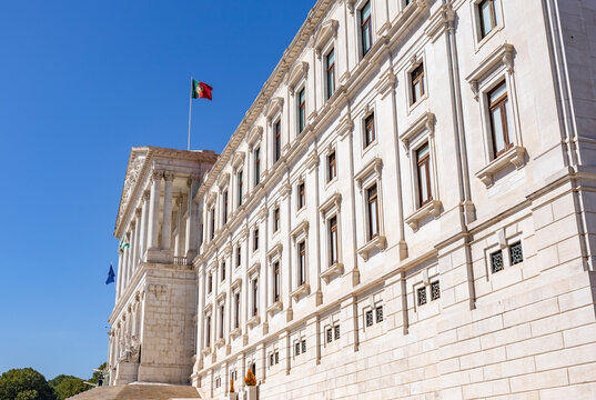Facade of Sao Bento Palace (Palacio de Sao Bento) building of the Portuguese Parliament (Parlamento de Portugal), and the Portuguese Flag on the top.