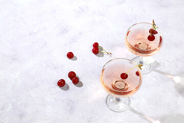 Modern still life with rose wine, alcoholic cocktail and cherry berries on elegant modern...