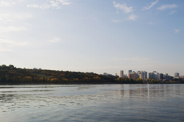 Fototapeta premium view of the city and river. landscape of a big river with steep banks. clouds over the blue river. dawn over the lake