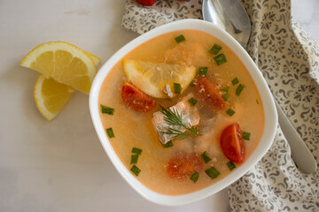 Soup with salmon, lemon on old background