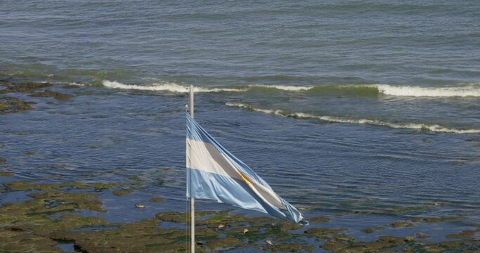 argentine flag blowing in the wind at the seaside