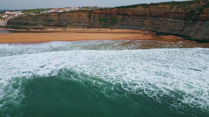 Aerial view rippling ocean waves washing beach. Sea surf covering empty seashore