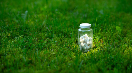 White capsules with medicine on a green natural background.Dietary supplements pills.Natural medicines.