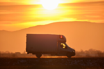 Cargo truck driving on highway hauling goods in evening. Delivery transportation and logistics...