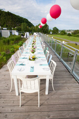 Dining table set up at outdoor wedding reception.