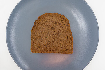 A single slice of delectable seeded rye bread displayed on a minimalist gray plate