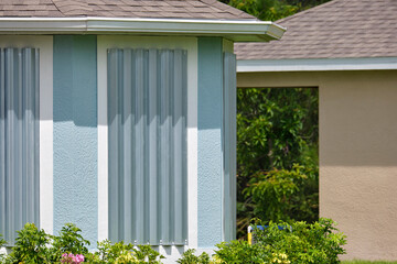 Steel sheets mounted as storm shutters for hurricane protection of house windows. Protective measures before natural disaster in Florida