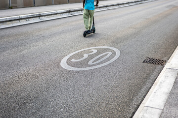 Signalisation voie limitée à 30 km/h - vue sur une trottinette - peinture blanche sur route -...