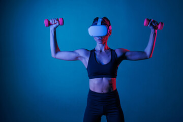 athletic girl doing sports online in VR glasses on a dark background, online sports training
