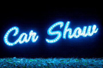 Car Show text lit up in blue lights with back background