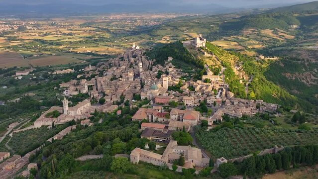 Aerial view of Assisi medieval town, Basilica of St. Francis, Rocca Maggiore, Santa Maria sopra Minerva Church, Cathedral of San Rufino, summer morning, Umbria, Italy