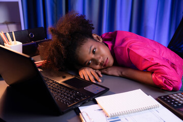 African woman freelancer feeling tried and take a nap on desk around by laptop and stationary,...