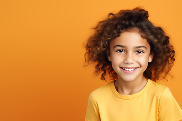 a girl smiling looking at camera on solid color background. space for text