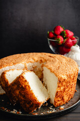 Sliced Angel Food Cake with Strawberries and Whipped Cream: Slices of sponge cake with fresh berries and whipped topping in the background