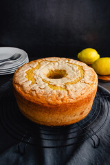 Lemon Pound Cake on a Round Wire Cooling Rack: Pound cake made in a tube pan shown with lemons, plates, and forks