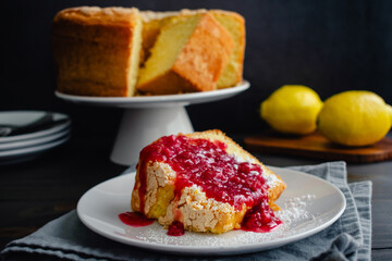 Lemon Pound Cake Slice with Raspberry Sauce Topping: A slice of lemon cake on a dessert plate with fruit sauce and powdered sugar on top