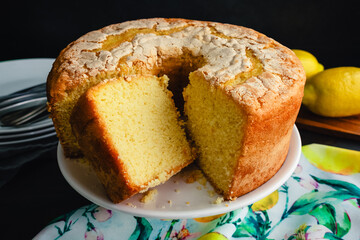 Lemon Pound Cake on a White Cake Stand: Close-up view of a sliced yellow cake without glaze on a white ceramic cake stand