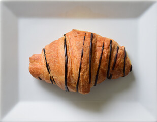 Close up chocolate croissant on a white plate