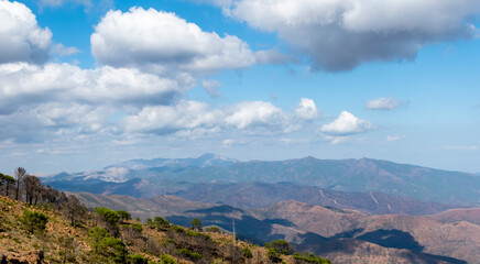 Picturesque mountains against blue sky with light clouds in sunlight