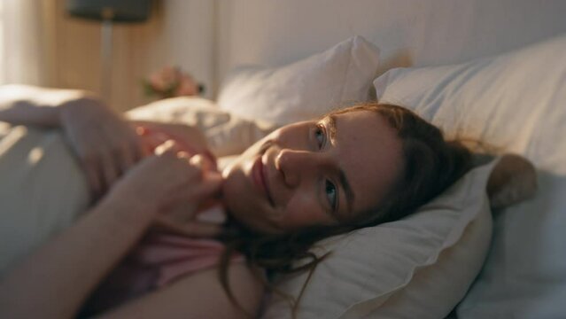 Happy girl looking smartphone screen in bed closeup. Sleepy female read message