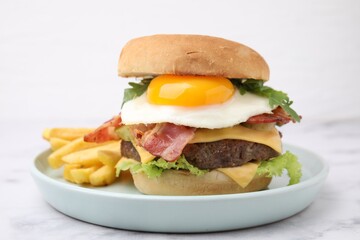 Delicious burger with fried egg and french fries served on white marble table, closeup