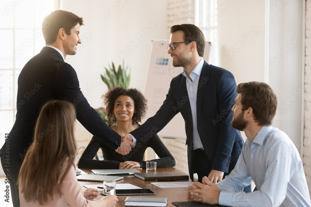 Canvas Prints two successful managers men in formal jackets greeting each other on team meeting, giving partnershi