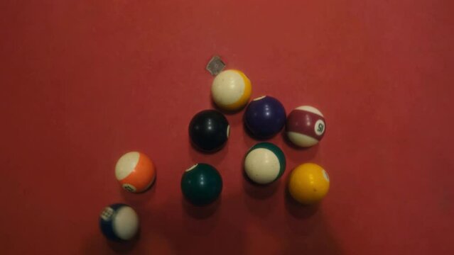 Top view of the beginning of the billiard game breaking balls. The moment of playing billiards on a table with a red vintage coating. First hit with white ball on triangle of balls. Film grain texture