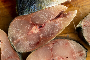raw yellow-tailed fish during cutting for cooking