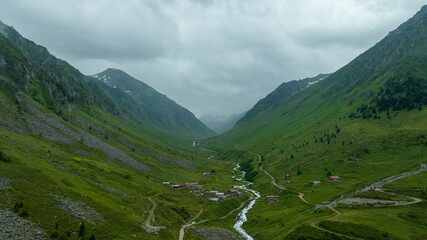 mountain peak and the river flowing through it. Green mountains black rain clouds. Great view from mountain peak
