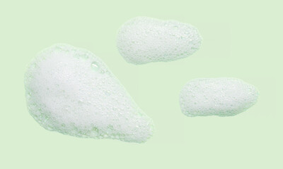 Skincare cleanser foam texture with bubbles isolated on green background. Soap shampoo face wash cleansing musse product sample
