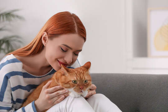 Woman with her cute cat at home, space for text