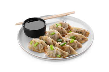 Delicious gyoza (asian dumplings) with green onions, soy sauce and chopsticks isolated on white