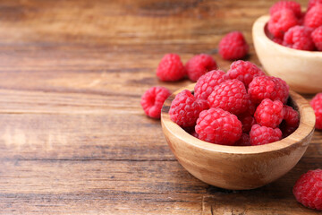 Tasty ripe raspberries on wooden table, space for text
