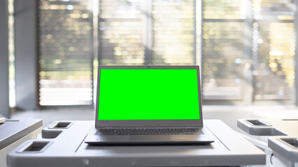 Open laptop with a blurry background and a green screen. - obrazy, fototapety, plakaty