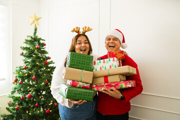 Portrait of a happy couple with a lot of christmas gifts