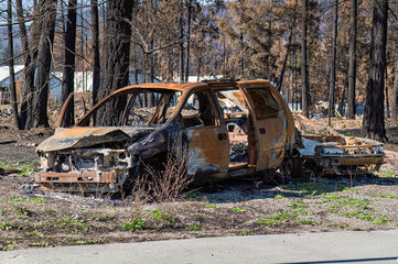 A partially burned van and another car awaits final disposal after the Lower East Adams Lake...