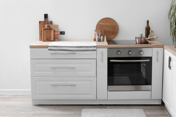 White kitchen counters with cutting boards, electric stove and oven