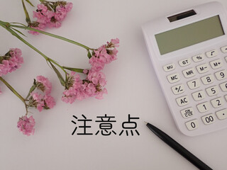 注意点の文字　ピンクの花と電卓