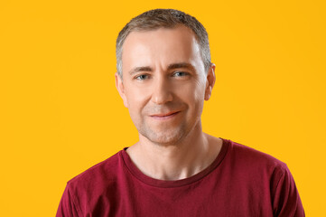 Portrait of handsome mature man on orange background