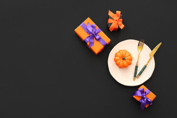 Halloween table setting with gift boxes and pumpkin on dark background