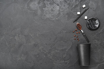 Composition with takeaway paper cup with coffee beans, sugar cubes and straws on black background