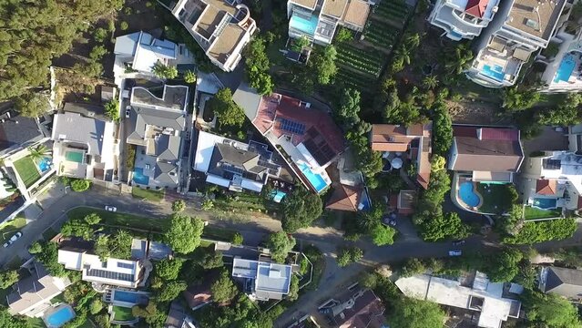 Aerial drone, property and buildings by mountain for architecture with street in urban settlement above. Top view path, road or small town suburb, outdoor environment or neighborhood land structure