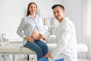 Fototapeta premium Young pregnant woman visiting doctor in clinic