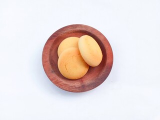 Cookies on a plate. Small round yellow bread in a wooden bowl isolated on a white background. sweet food. sweet bread.
